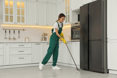 Photo of Woman cleaning floor with mop at home