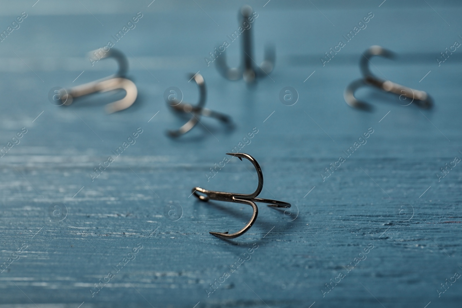 Photo of Fishing hooks on wooden table. Angling equipment