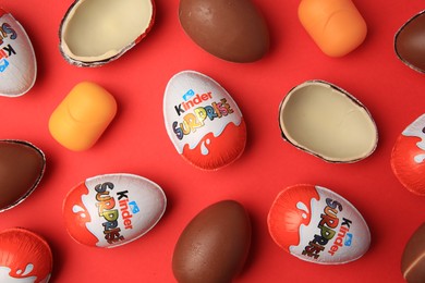 Photo of Sveti Vlas, Bulgaria - June 29, 2023: Kinder Surprise Eggs and plastic capsules on red background, flat lay