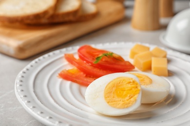 Plate with hard boiled egg on table, closeup