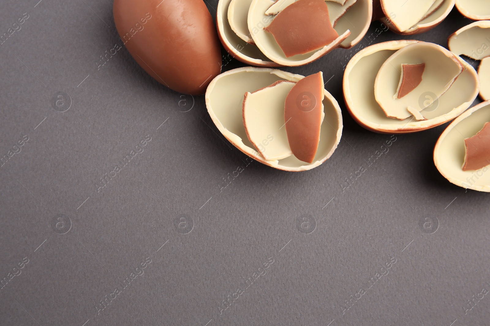 Photo of Sveti Vlas, Bulgaria - July 3, 2023: Broken halves of Kinder Surprise Eggs on grey background, flat lay. Space for text