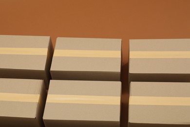 Photo of Many cardboard boxes on brown background, above view