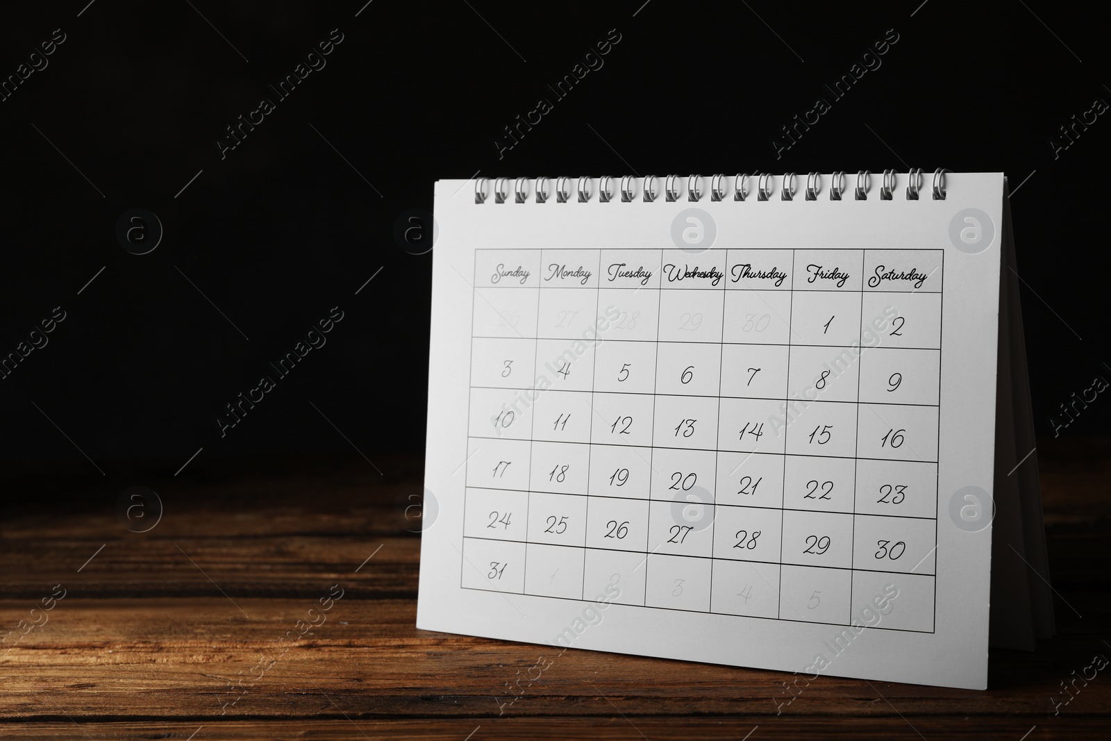 Photo of Paper calendar on wooden table, space for text. Planning concept