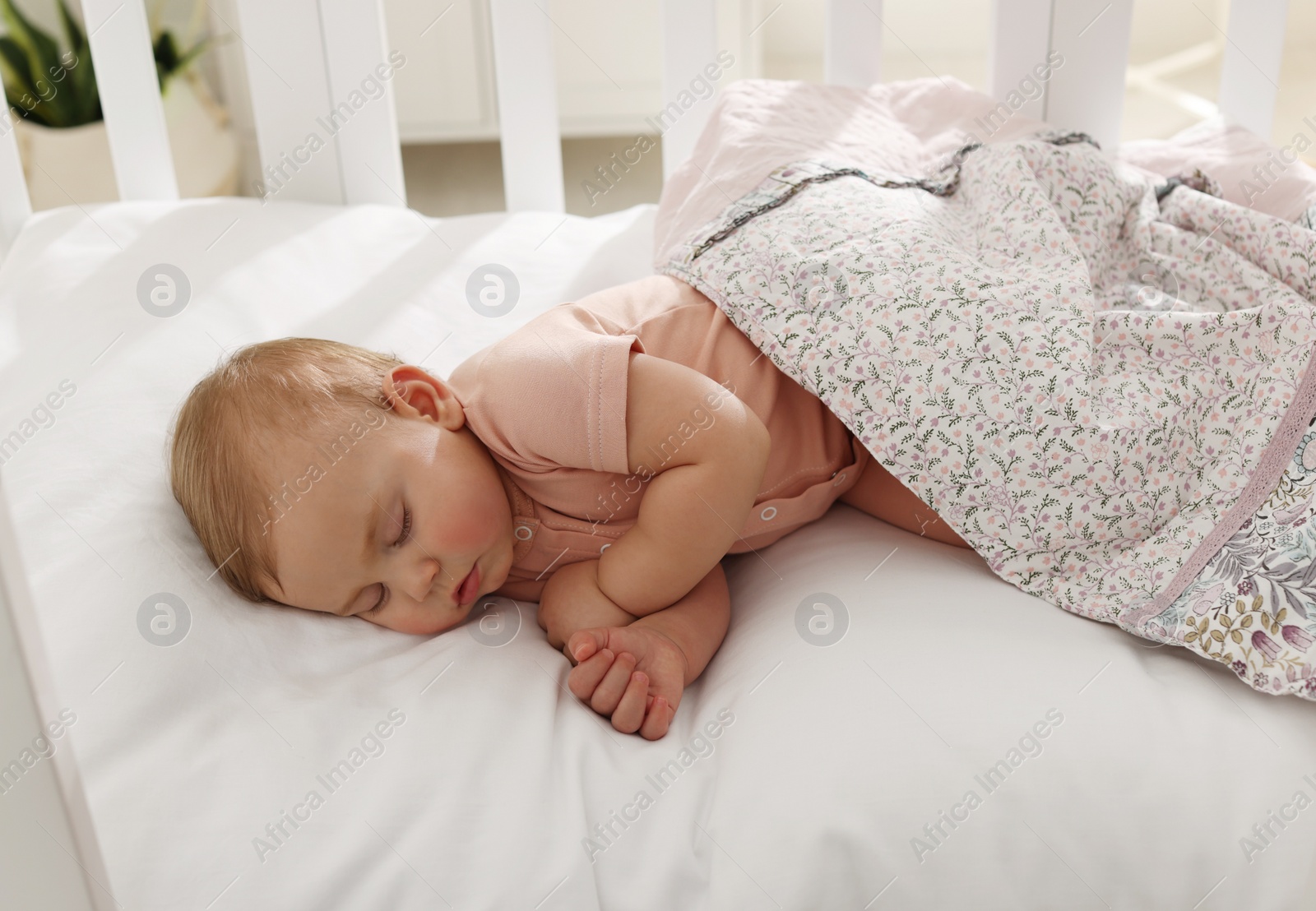 Photo of Cute little baby sleeping in soft crib at home