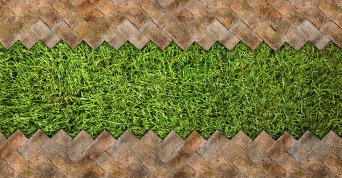 Image of Fresh green grass and tiled surface outdoors, top view. Banner design