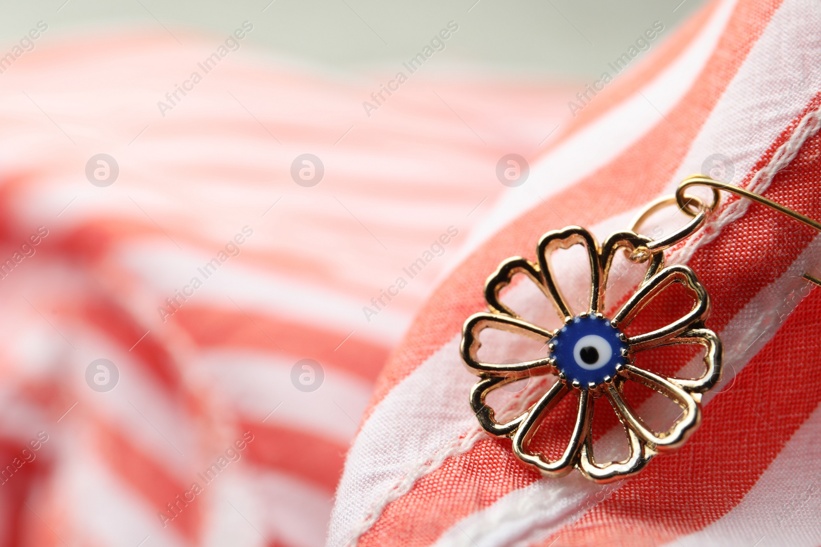 Photo of Evil eye safety pin on clothing, closeup