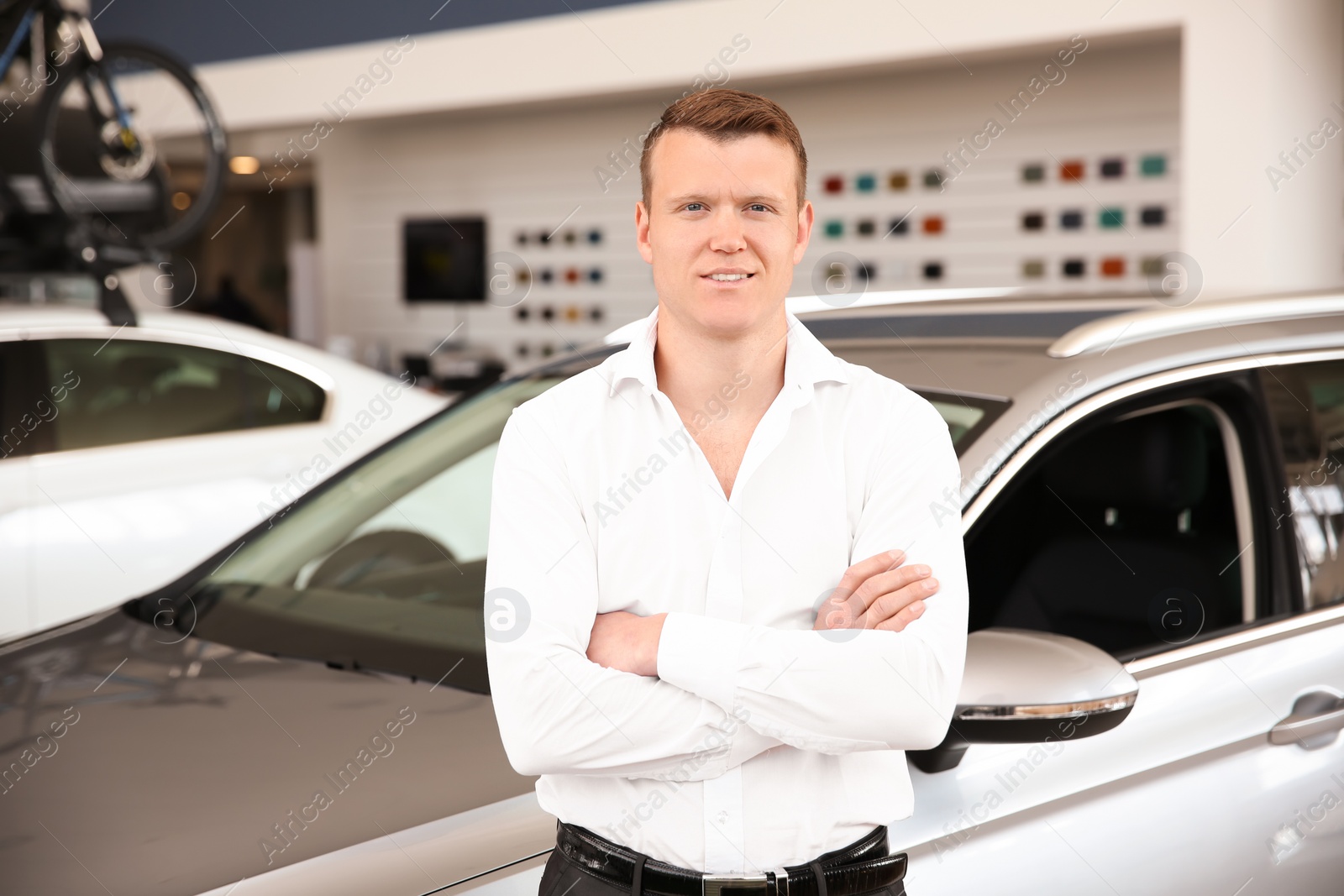 Photo of Portrait of young salesman in car dealership