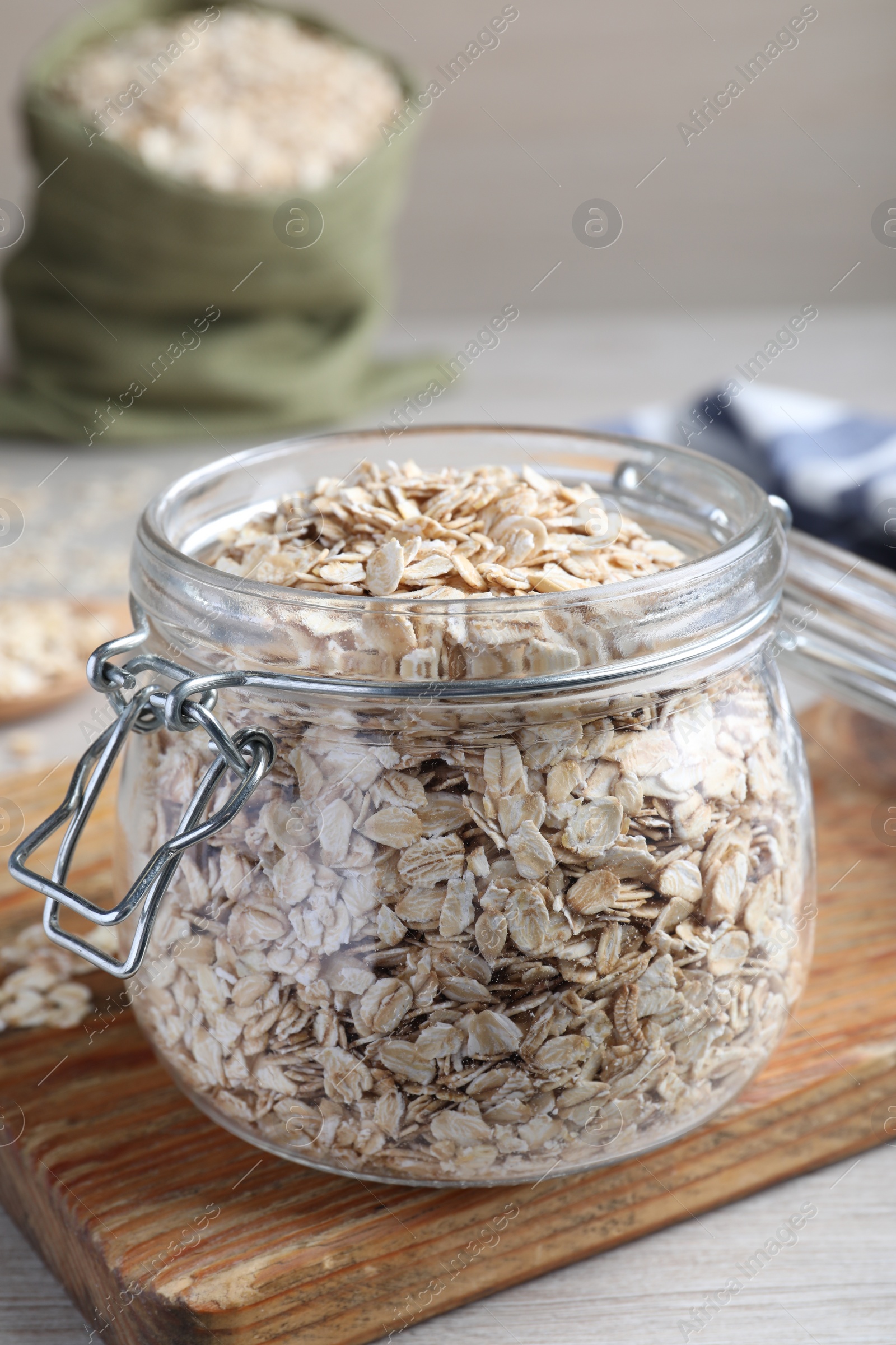 Photo of Glass jar with oatmeal on white wooden table