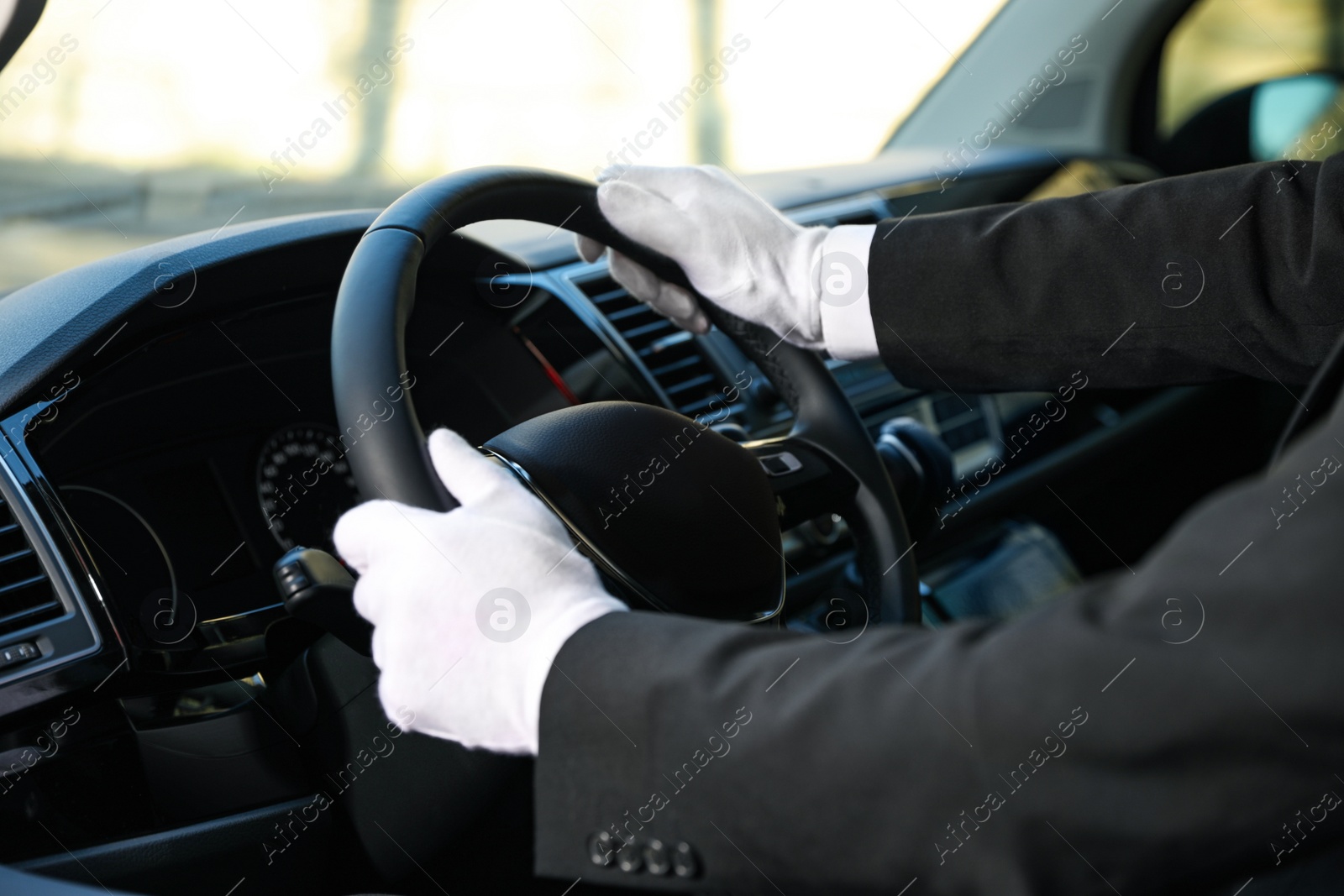 Photo of Professional driver in luxury car, closeup. Chauffeur service