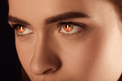 Woman with fire burning in her eyes, closeup. Evil eye