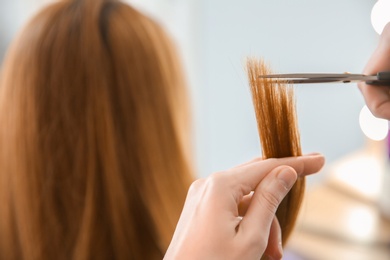 Photo of Professional hairdresser working with client in salon