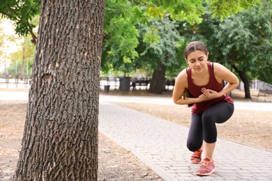 Young woman having heart attack while running in park