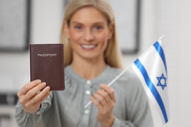 Immigration. Happy woman with passport and flag of Israel indoors, selective focus