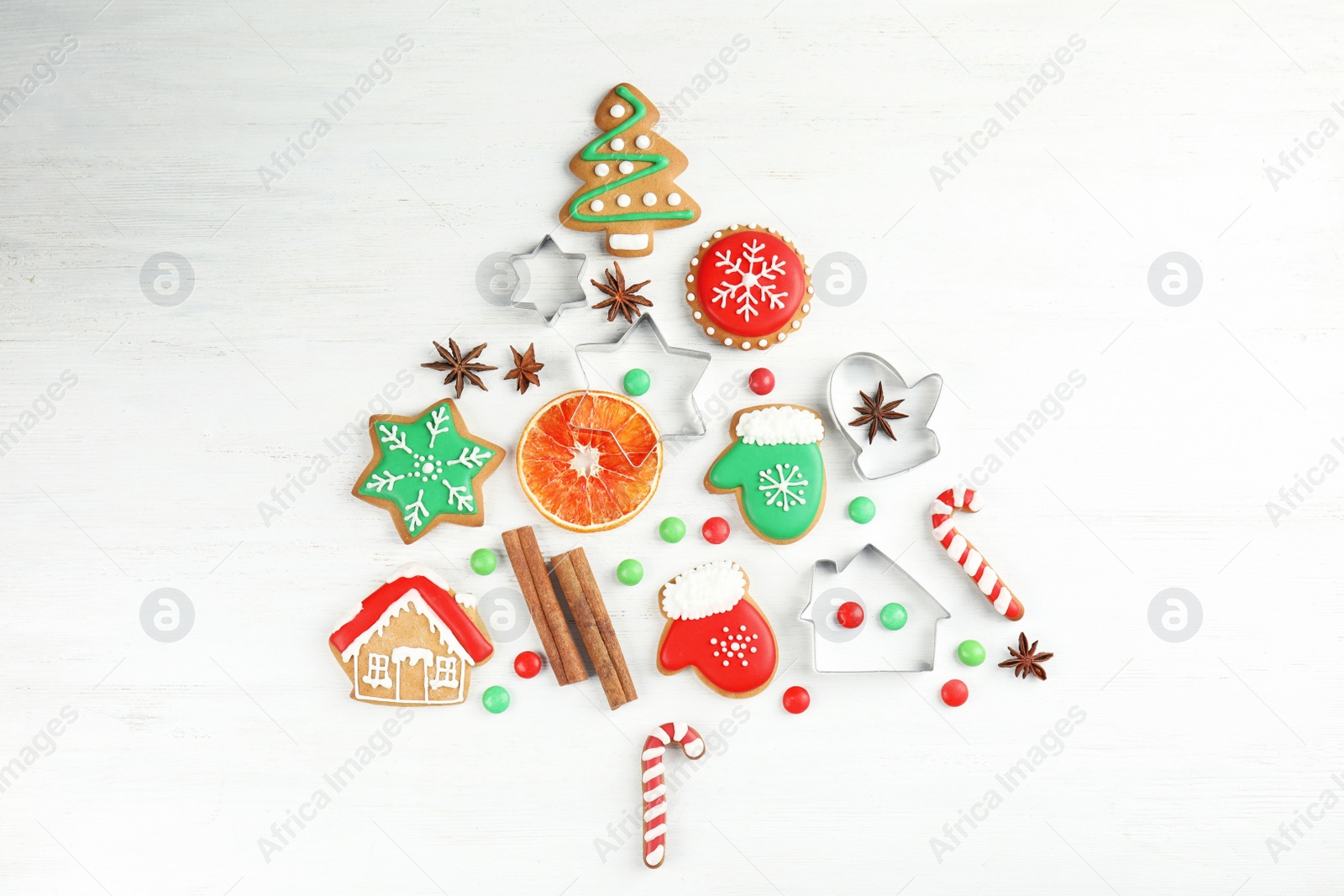 Photo of Christmas tree shape made of tasty homemade cookies on wooden background, top view