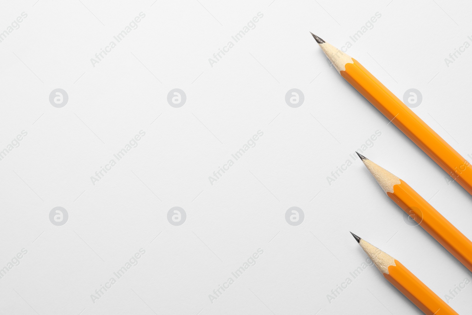 Photo of Sharp graphite pencils on white background, flat lay. Space for text
