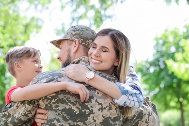 Photo of Male soldier with his family outdoors. Military service
