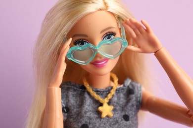 Photo of Mykolaiv, Ukraine - September 4, 2023: Beautiful Barbie doll with stylish eyeglasses on lilac background