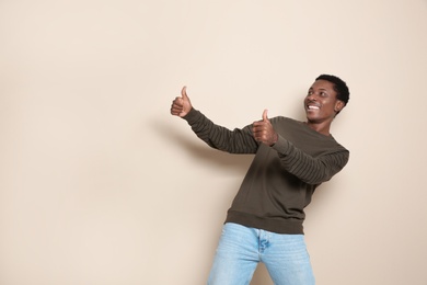 Photo of Portrait of emotional African-American man on color background. Space for text