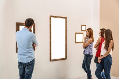 Photo of People viewing exposition in modern art gallery