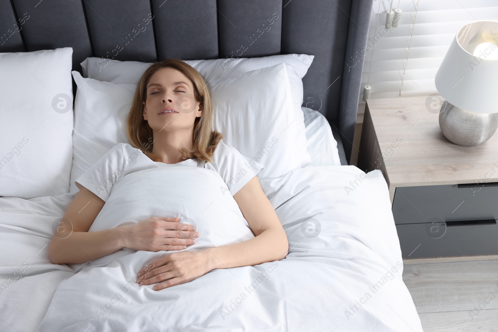 Photo of Woman snoring while sleeping in bed at home