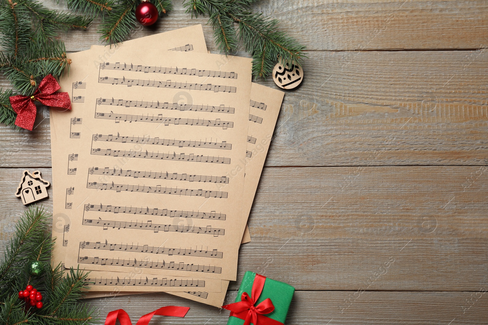 Photo of Flat lay with Christmas music sheets on wooden background, space for text