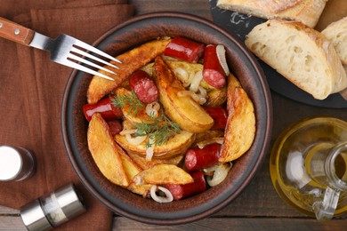 Photo of Delicious baked potato with thin dry smoked sausages in bowl served on wooden table, flat lay