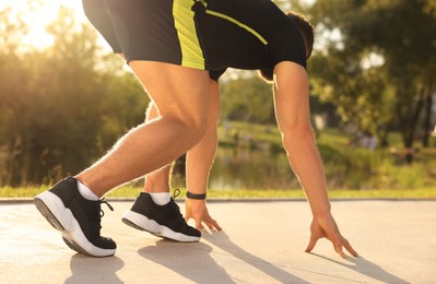 Photo of Runner on starting position in park on sunny day, closeup