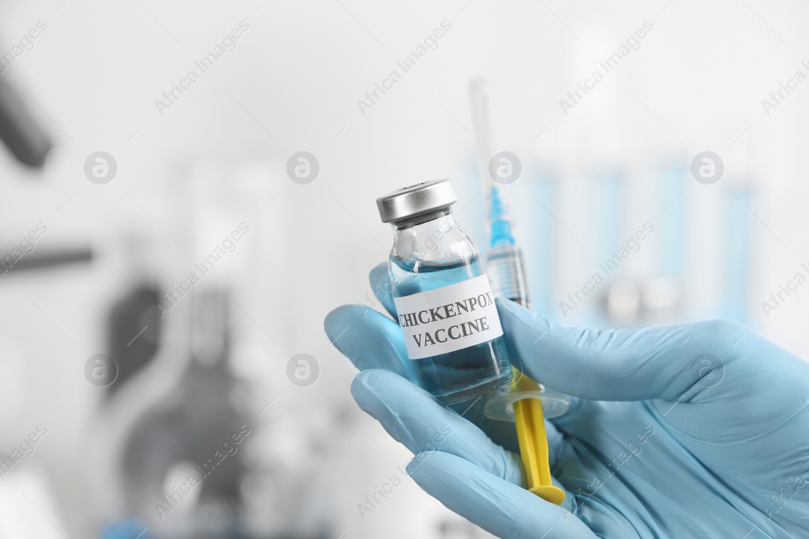 Photo of Doctor holding chickenpox vaccine and syringe in laboratory, closeup. Varicella virus prevention