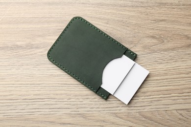 Photo of Leather business card holder with cards on wooden table, top view