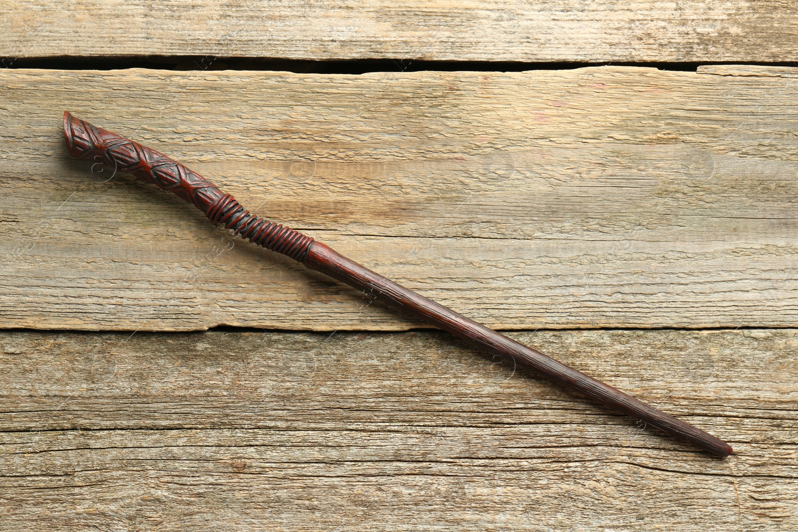 Photo of One old magic wand on wooden table, top view