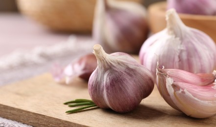 Photo of Bulbs and cloves of fresh garlic on table, closeup. Space for text