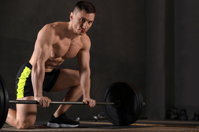 Photo of Strong man lifting barbell in modern gym