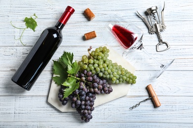 Photo of Flat lay composition with fresh ripe juicy grapes and wine on white wooden table