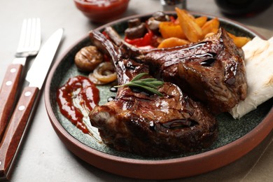 Photo of Delicious grilled ribs served on grey table, closeup
