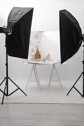 Photo of Christmas decor and double-sided backdrops on table in photo studio