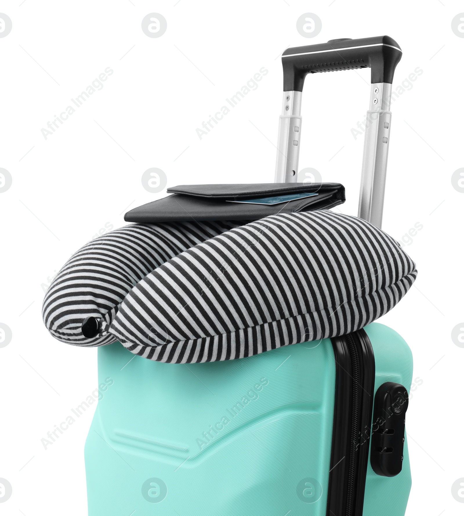 Photo of Soft travel pillow and purse on turquoise suitcase isolated on white