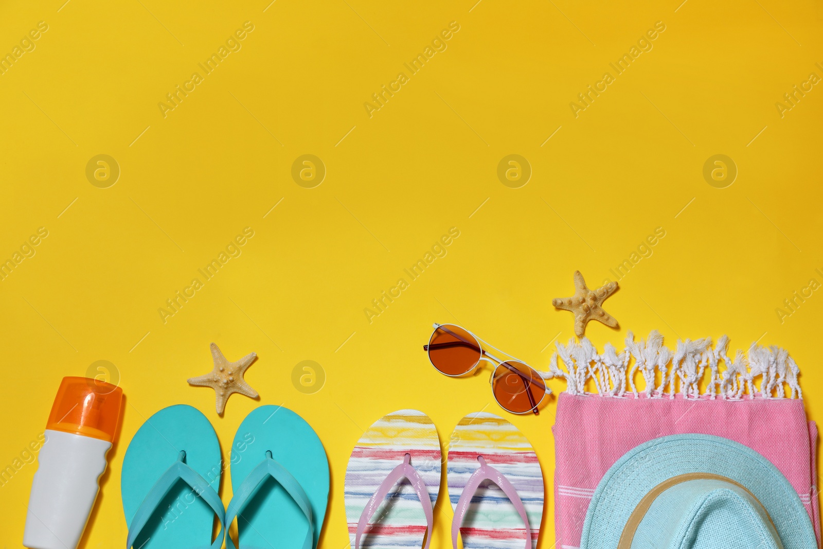 Photo of Flat lay composition with summer beach accessories on yellow background. Space for text