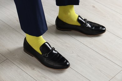 Photo of Man wearing stylish shoes and yellow socks indoors, closeup