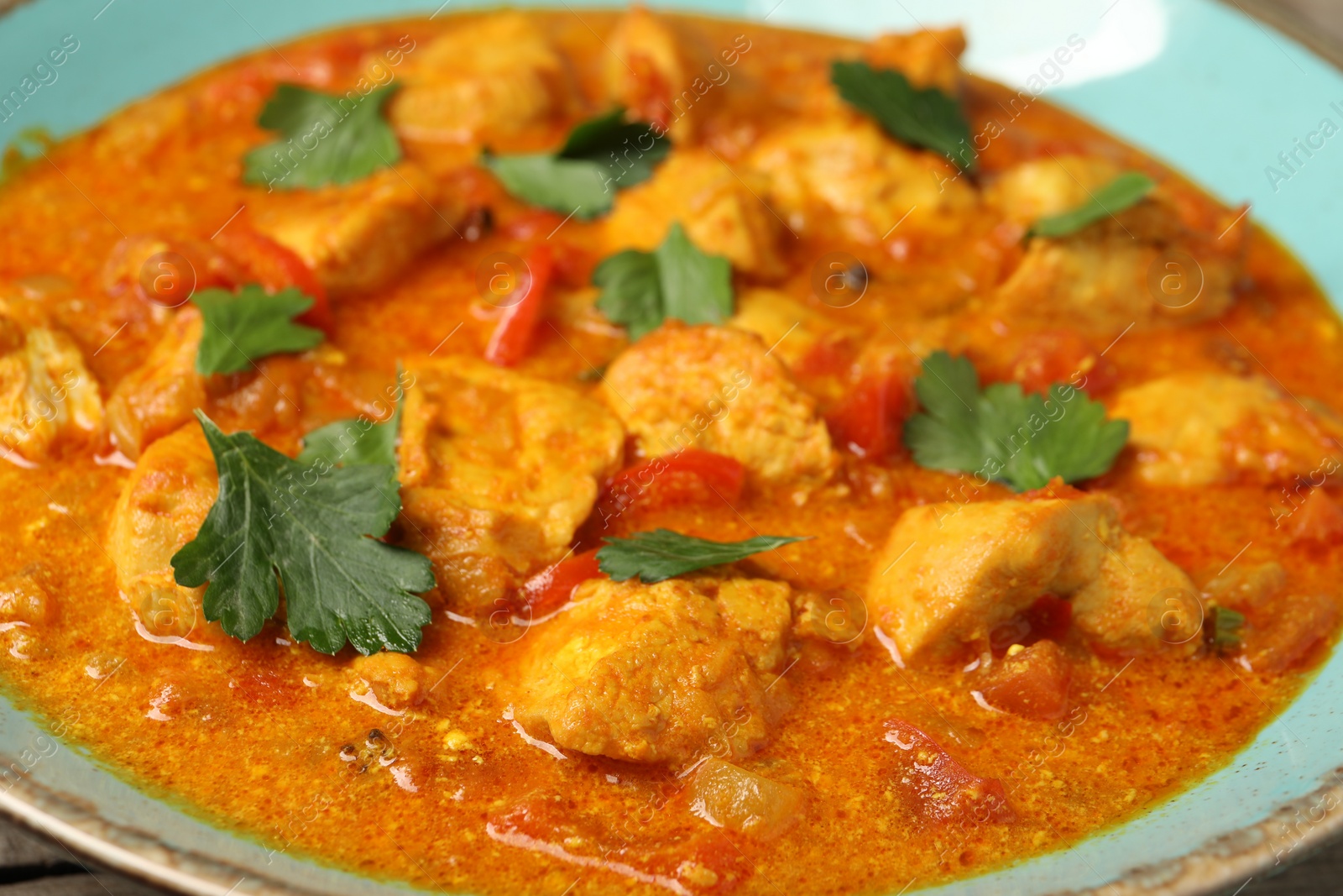 Photo of Delicious chicken curry with parsley in plate, closeup