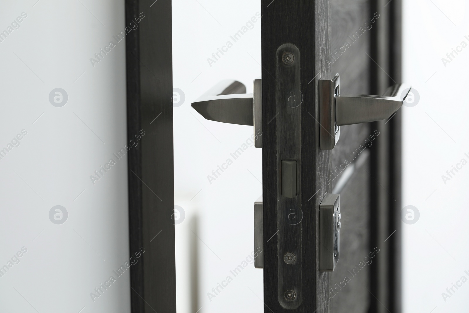 Photo of Open wooden door with metal handle, closeup