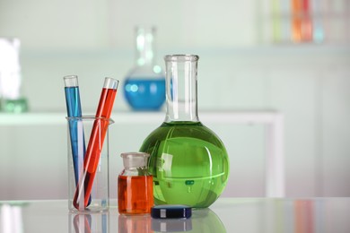 Laboratory analysis. Different glassware with liquids on white table against blurred background