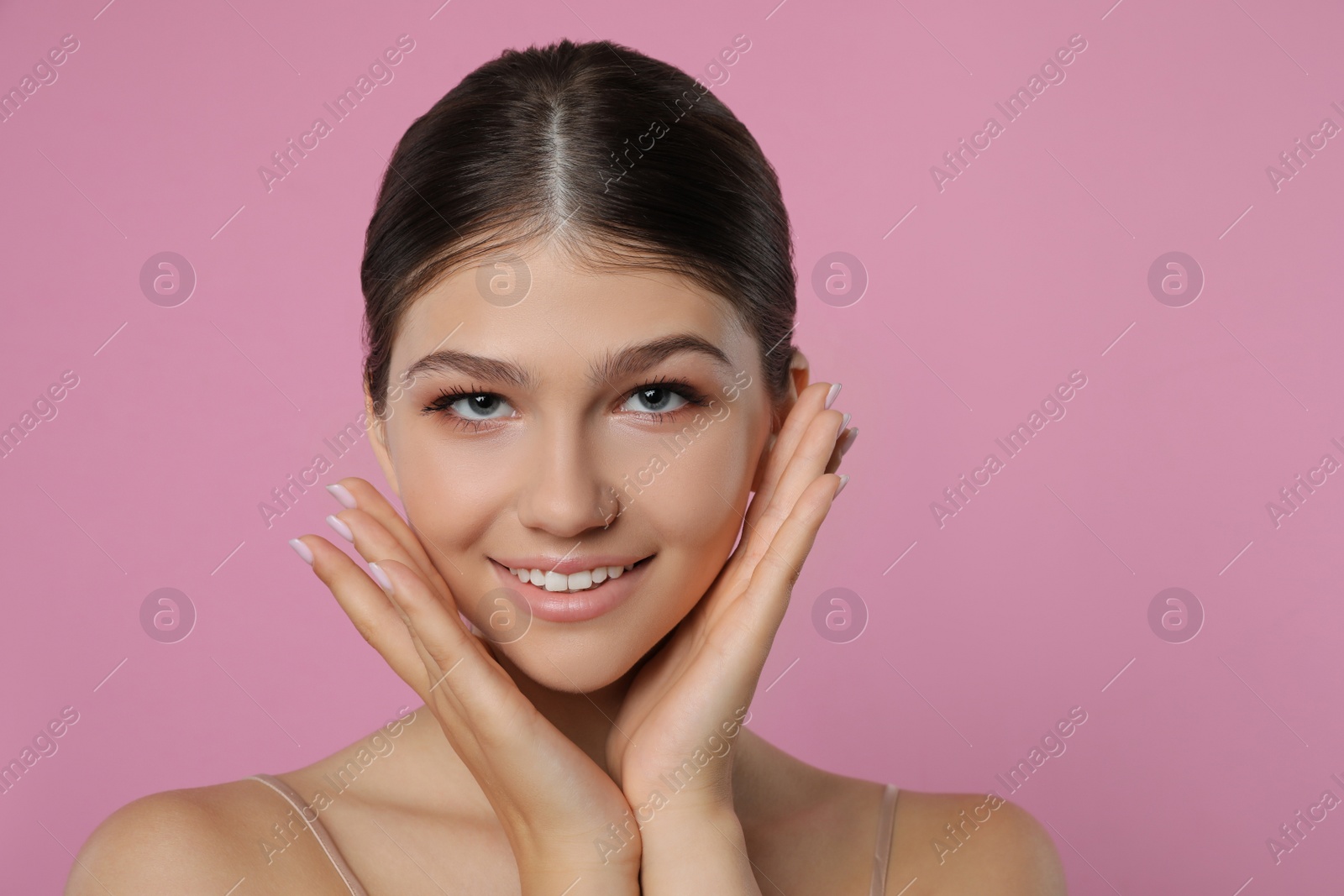 Photo of Portrait of pretty girl on pink background, space for text. Beautiful face with perfect smooth skin