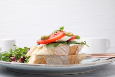 Photo of Tasty bruschetta with tomatoes, olives and mozzarella on plate, closeup