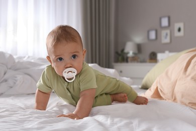 Photo of Cute baby crawling on bed at home