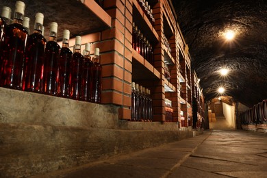 Beregove, Ukraine - June 23, 2023: Many bottles of alcohol drinks on shelves in cellar, low angle view