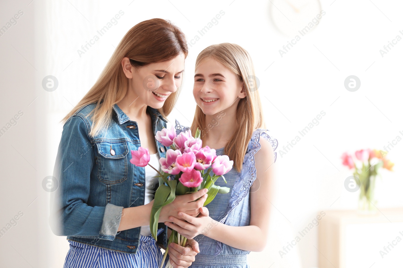 Photo of Teenage daughter congratulating happy woman on Mother's Day at home