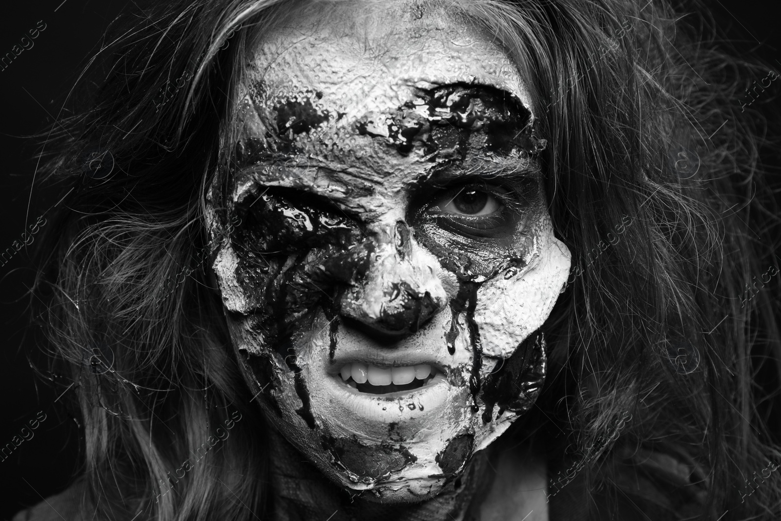 Photo of Scary zombie on dark background, black and white effect. Halloween monster