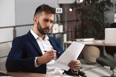 Man working with document at table in office