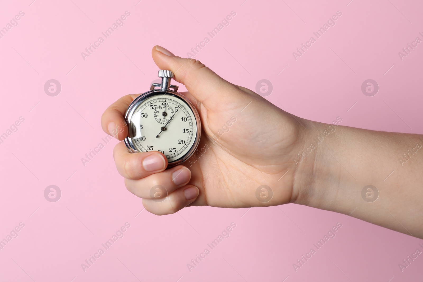 Photo of Woman holding vintage timer on pink background, closeup