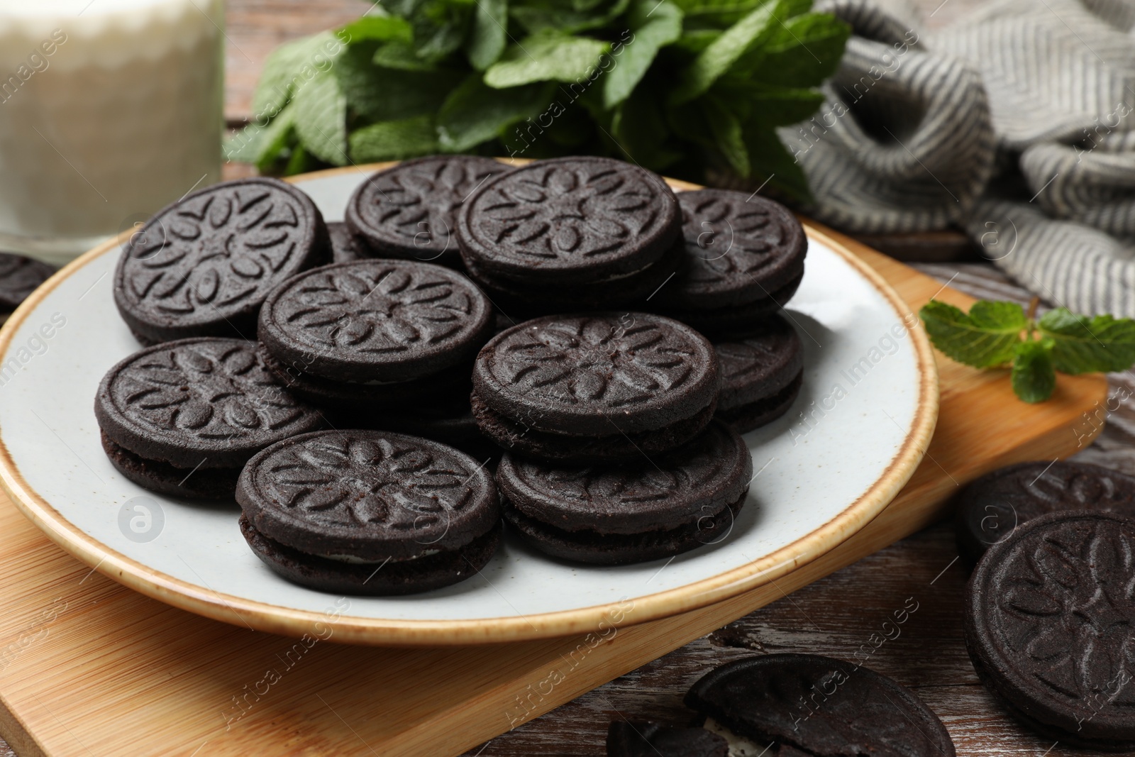 Photo of Plate with tasty sandwich cookies on wooden table, closeup